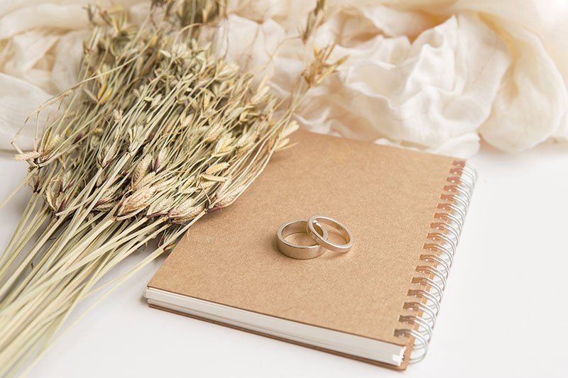 Une image de carnet avec deux anneaux et un bouquet champêtre