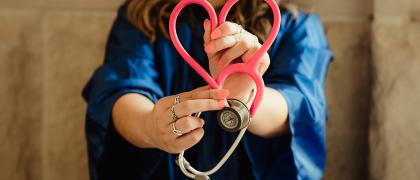 Femme tenant en stéthoscope en forme de coeur