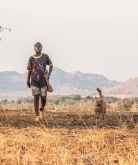 un garçon et son chien qui marchent dans la savane
